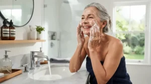 A woman incorporating products from anti-aging bar soap reviews for mature skin into her daily morning bathroom skincare routine.