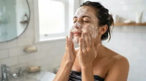 A person gently cleansing their face with rich lather from an acne bar soap.